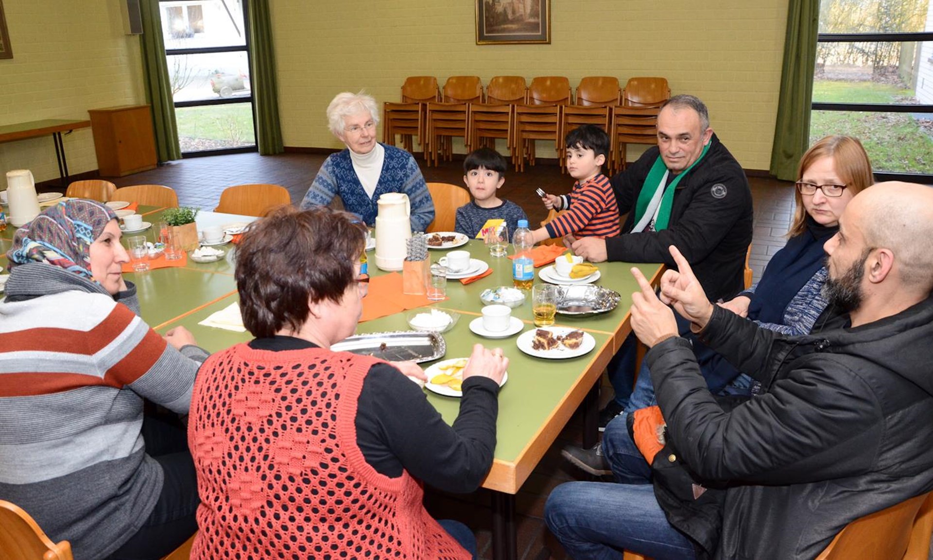 Menschen aus dem Stadtteil Lürrip sitzen an einem Tisch im Caritas-Familiencafé